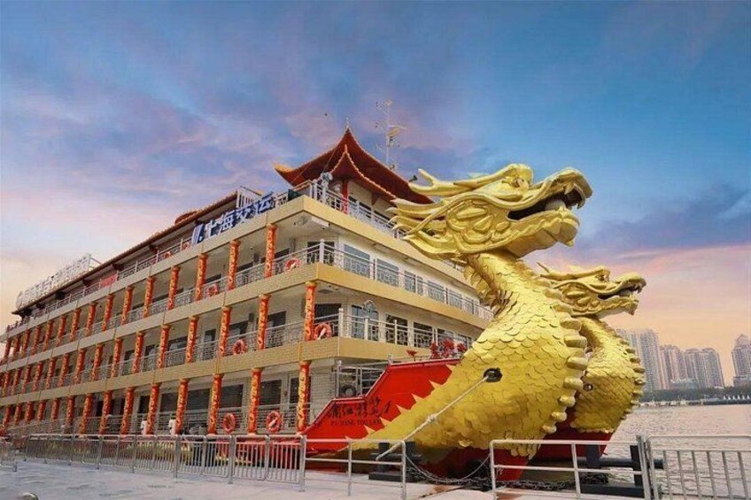A large dragon statue next to a multi-story building with balconies. 3