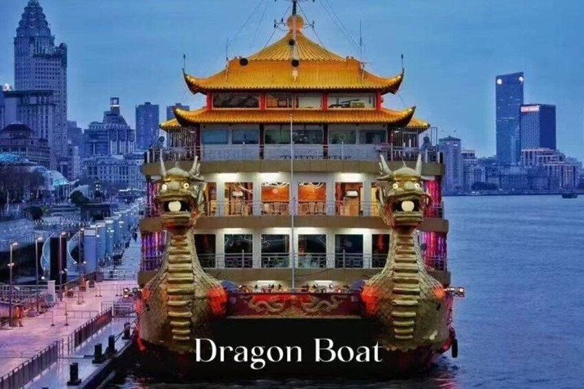 Un bateau-dragon aux décorations élaborées, avec la silhouette d’une ville en arrière-plan et une étendue d’eau. 1
