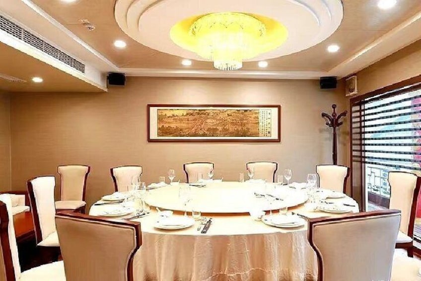 Un salón de conferencias con una mesa redonda, sillas y un candelabro. 2