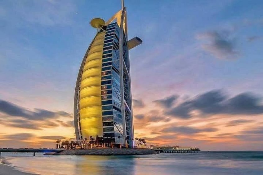 Un edificio grande y de forma peculiar junto al agua durante el atardecer. 2