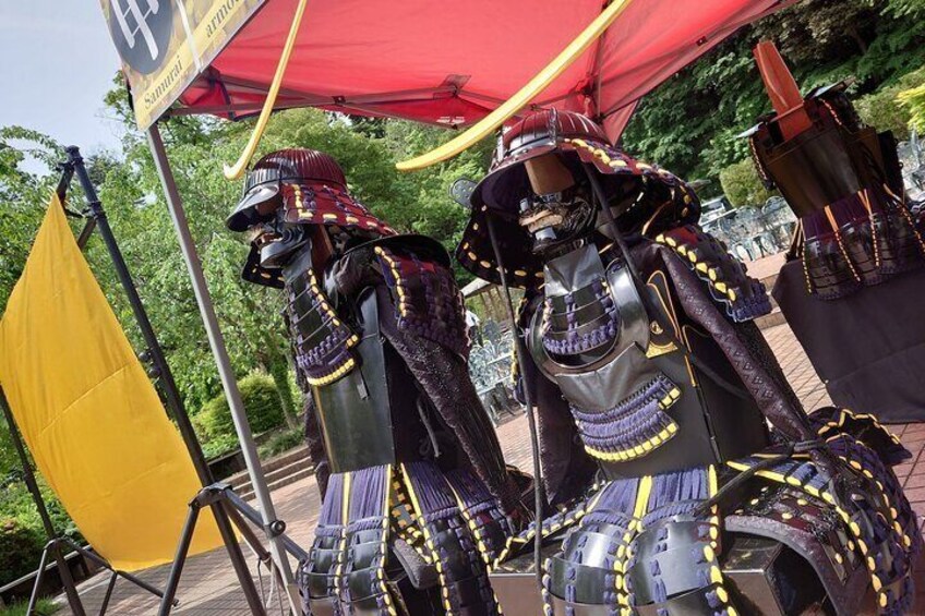 Two samurai in elaborate armor under a red canopy. 1