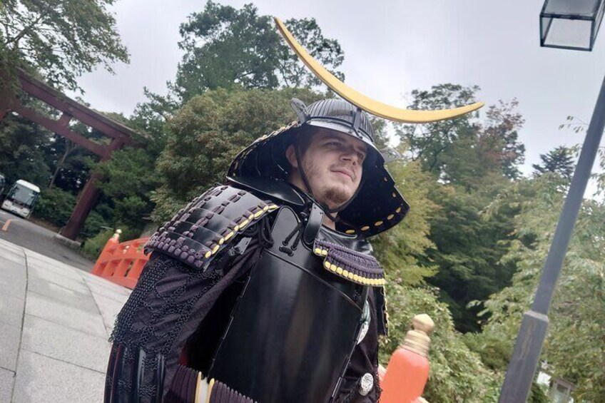 A person in a samurai costume with a helmet and a sword. 3