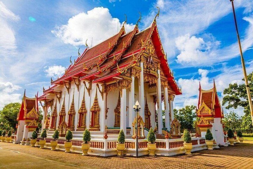 A traditional Thai temple with ornate architecture, a red and white color scheme, and a clear blue sky. 5