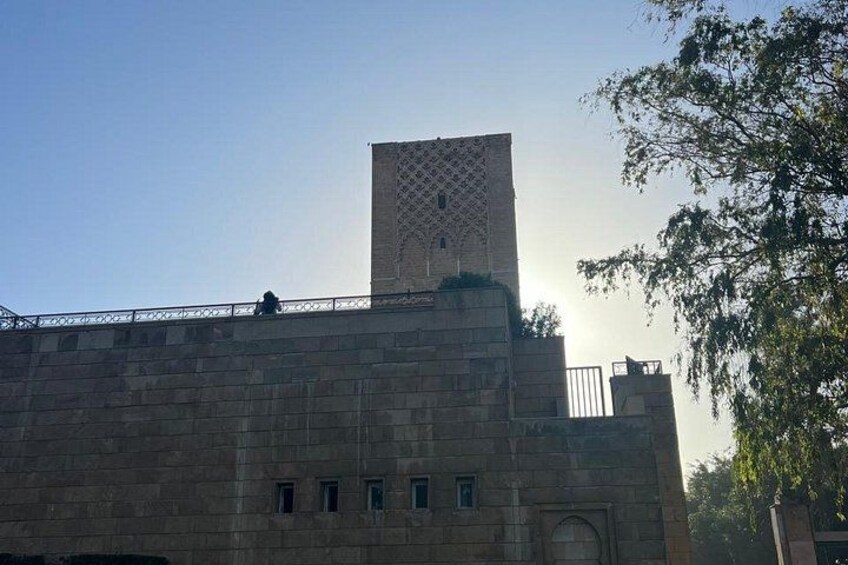 A stone building with a tower and a metal fence. 3