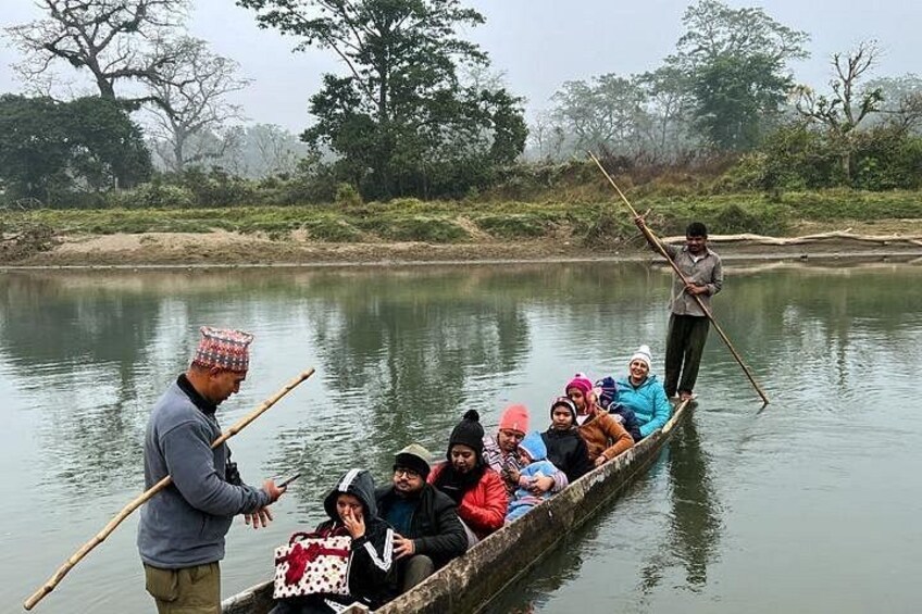 A group of people in a narrow boat on a calm river, with a guide standing at the stern. 3