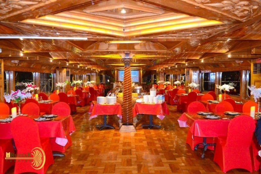 A restaurant with red tables and chairs, wooden flooring, and a central pillar. 4