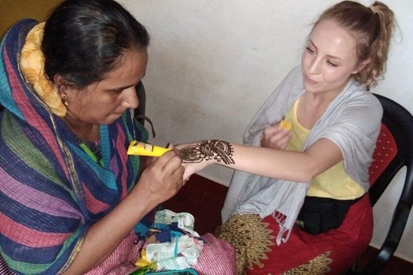 Eine Person trägt Henna auf den Arm einer anderen Person auf. 2