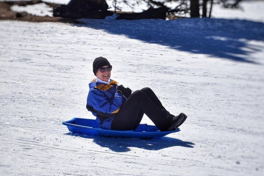 A person sledding down a snowy slope. 4