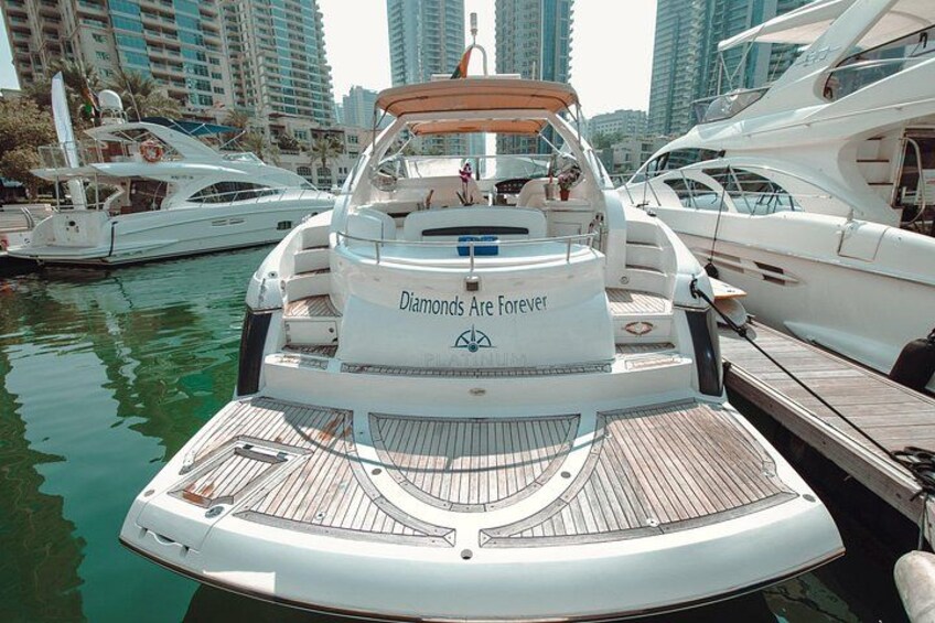A yacht docked at a marina with other boats, surrounded by high-rise buildings. 5
