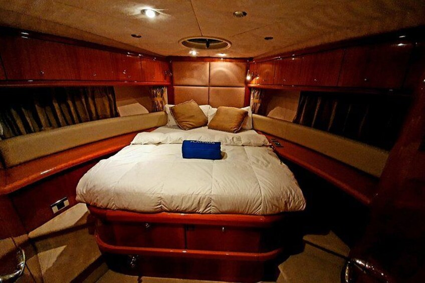 A luxurious cabin with a large bed, wooden paneling, and a red accent wall. 4