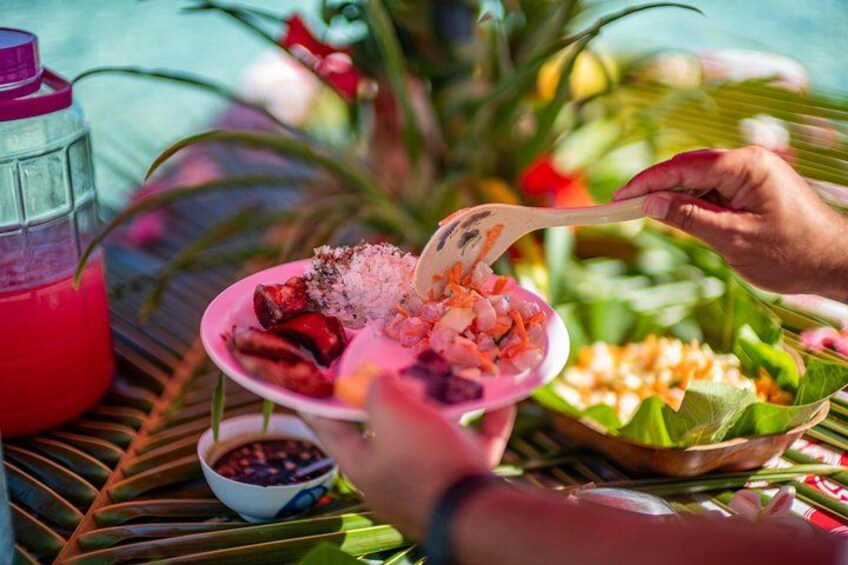 A person eating a meal with a variety of foods including rice, vegetables, and meat, with a tropical setting in the background. 2