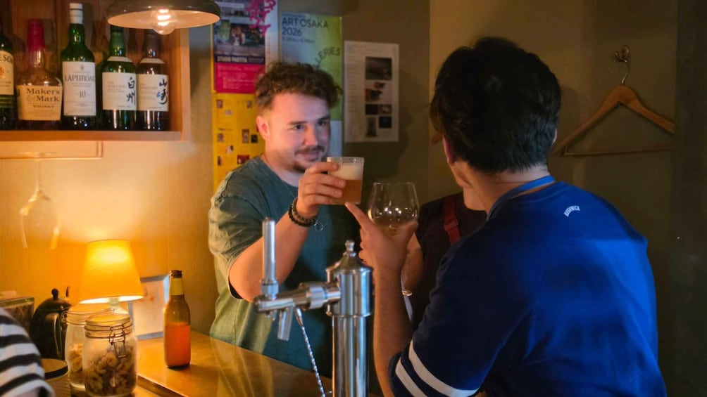 En bar med flasker og et billede på væggen. 5