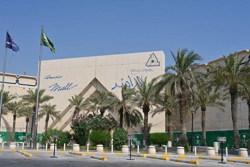 Un edificio con un letrero grande, palmeras y banderas. 2