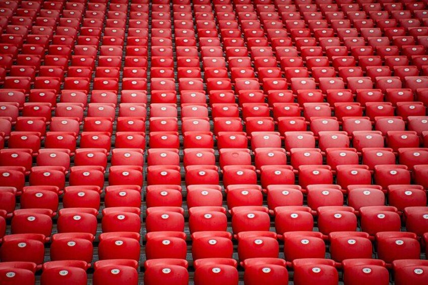 Rader av röda sittplatser på en stadion. 2