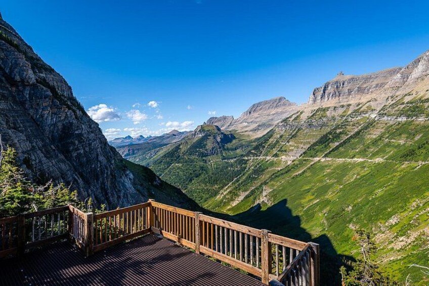 Une plateforme d’observation en bois surplombant un paysage montagneux sous un ciel dégagé. 5