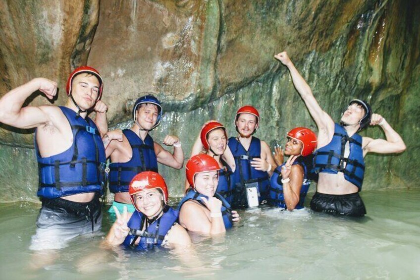 Un groupe de personnes se trouve dans une grotte, portant des gilets de sauvetage et des casques. 4