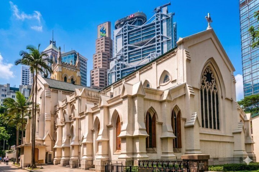 A historic church with arched windows and a pointed steeple, surrounded by modern skyscrapers. 5