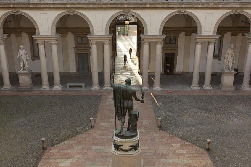 A courtyard with statues, columns, and a central pathway. 2