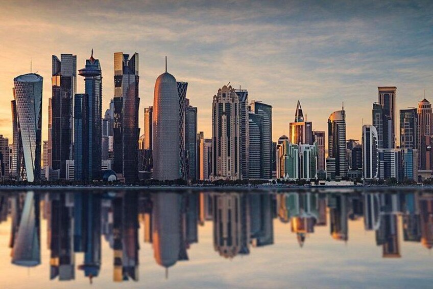 Horizonte urbano con rascacielos modernos y una masa de agua tranquila que refleja los edificios. 3