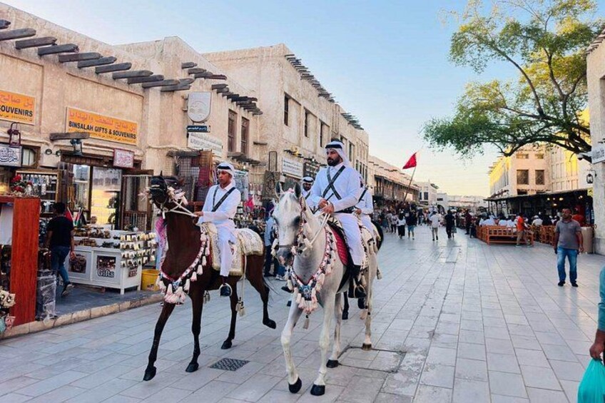 Dos hombres a caballo, una calle comercial y tiendas. 5