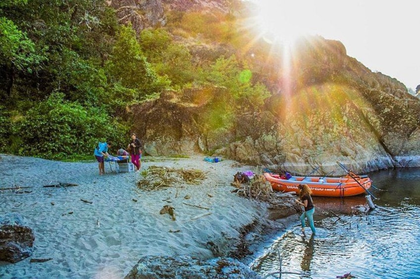 Group relaxing riverside as the sun fades over the Rogue River canyon 3