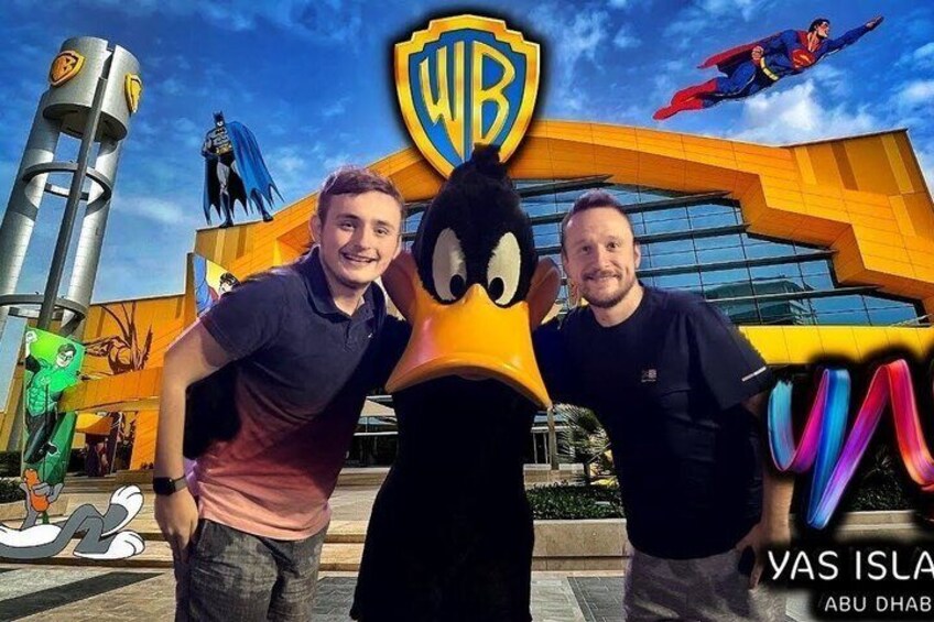 Two people with a Warner Bros. character in front of a building with a large WB logo. 2