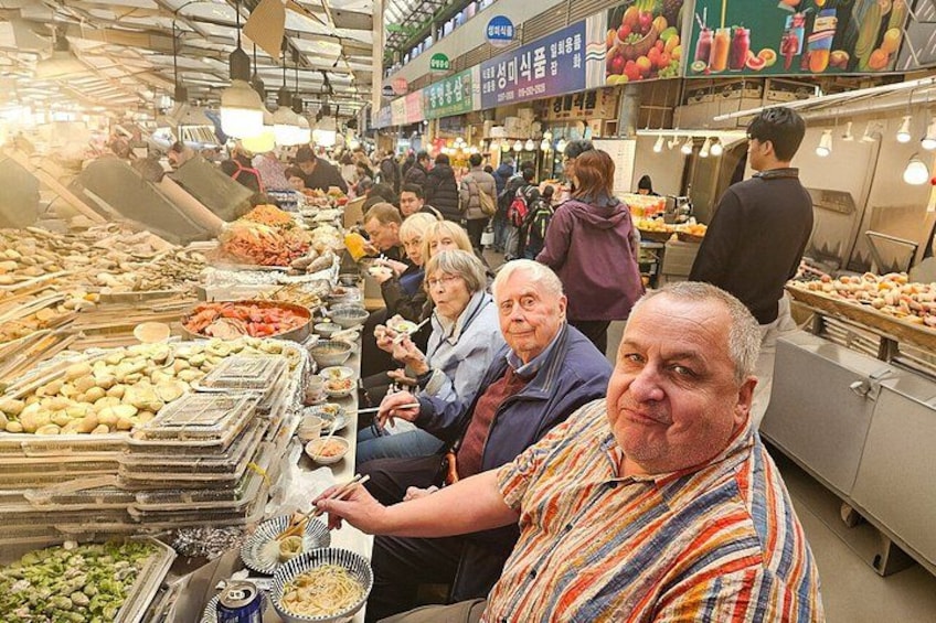 A busy market with people shopping and vendors selling goods. 4