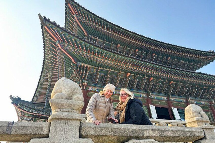 A traditional Korean building with a curved roof and stone lanterns. 1