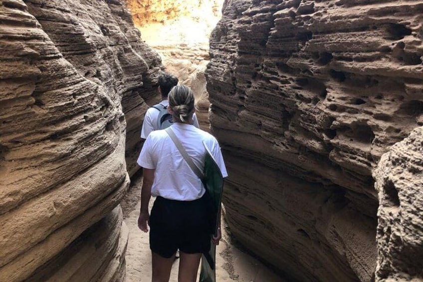 A narrow canyon with layered rock formations. 3