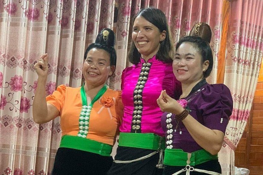 Three individuals in traditional attire with green sashes and floral patterns. 1