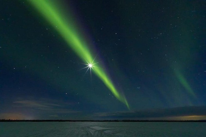 A night sky with aurora borealis over a calm body of water. 4