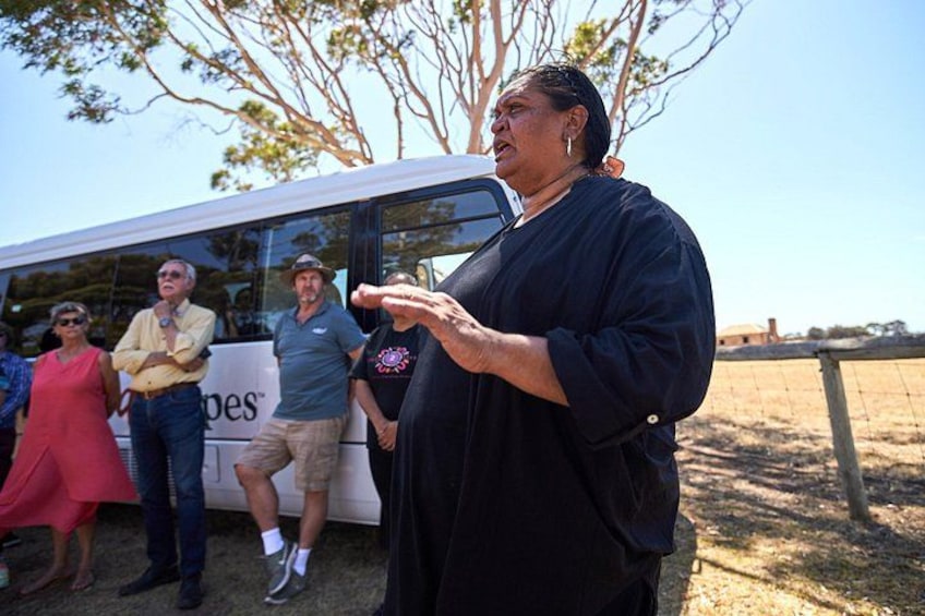 A person gesturing near a bus with a group of people standing behind. 3