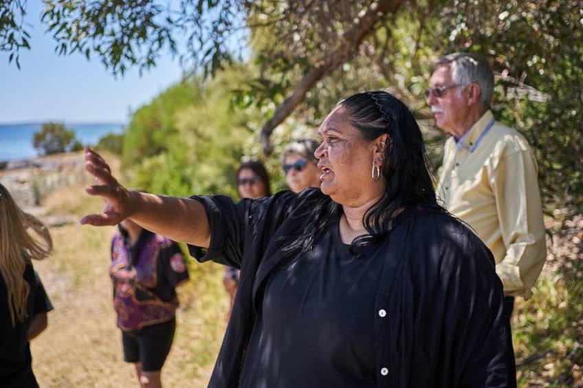 A group of people outdoors, with a woman gesturing. 2