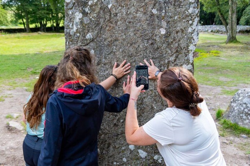 Three people taking a photo of a tree. 2