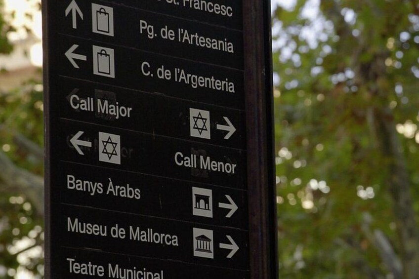Een richtingsbord met verschillende bestemmingen en symbolen. 4