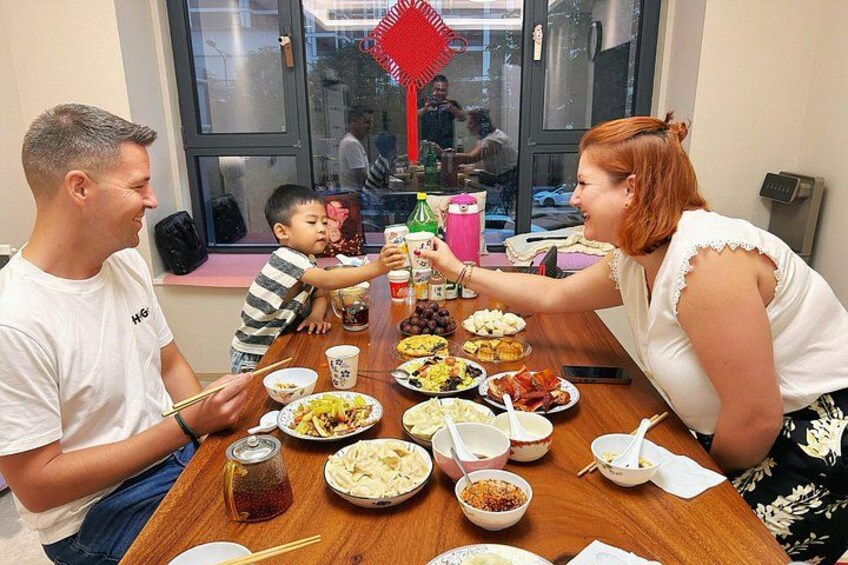 A family dining at a table with various dishes and drinks. 2