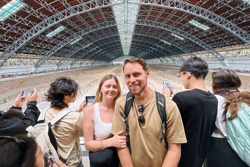 Un groupe de personnes prenant des photos dans un stade en plein air doté d’une grande structure de toit incurvée. 5