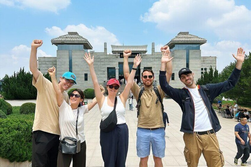 Un groupe de personnes posant devant un bâtiment moderne doté de deux grandes tours. 3