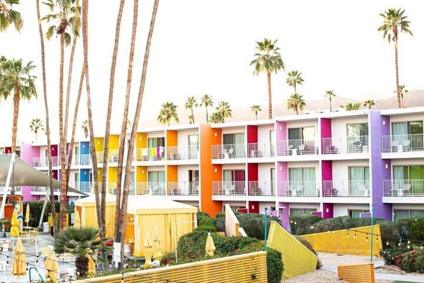 A colorful hotel with multiple balconies and palm trees. 2