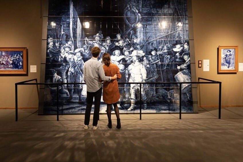 Una pareja observa un gran mural histórico en un museo. 2