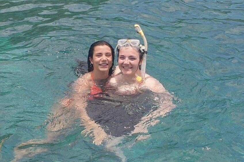 Two people in clear water, one wearing a snorkel. 3