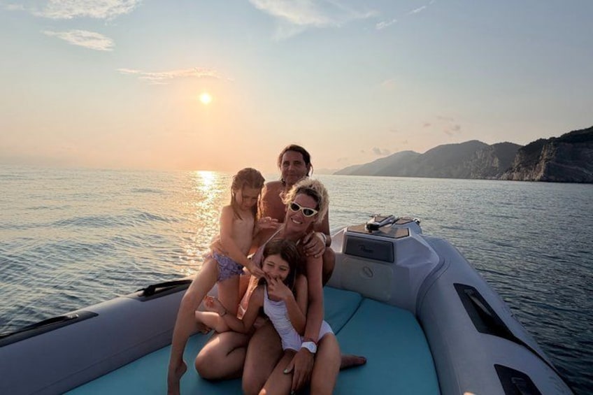 Una familia en un barco, con un atardecer de fondo. 4