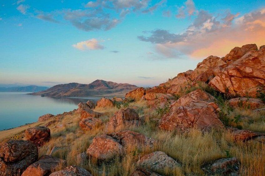 A rocky landscape with a body of water in the background. 3