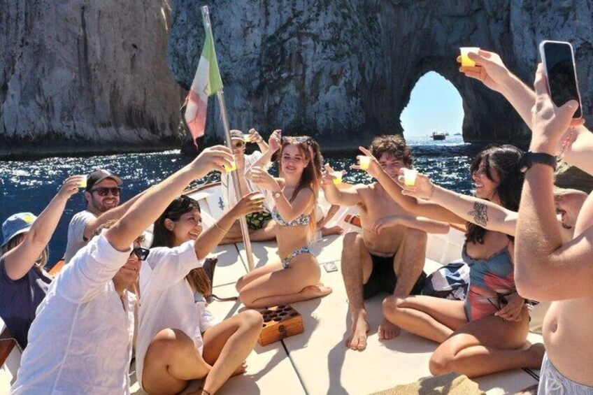 Un grupo de personas en un bote cerca de una costa rocosa bajo un cielo despejado. 1
