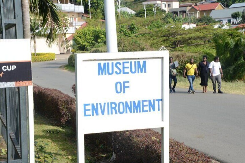A sign for the Museum of Environment with people walking in the background. 2