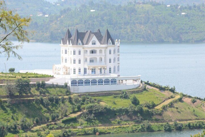 A large white castle by a lake surrounded by greenery. 4