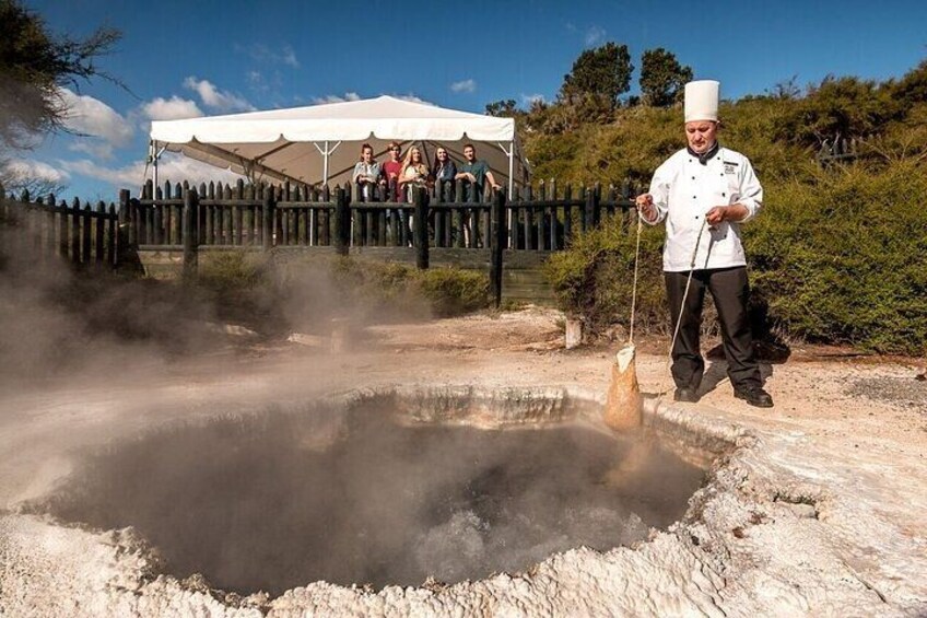 A chef cooking outdoors with a group of people watching. 5