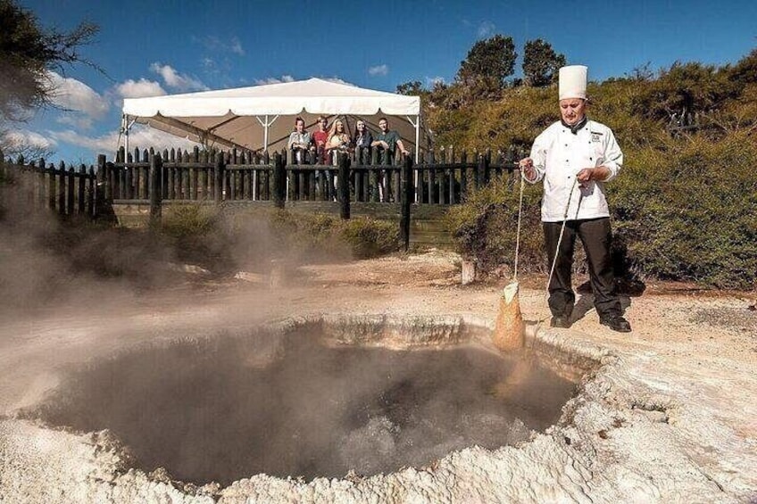 Un chef cuisine en plein air, devant une foule de spectateurs. 5