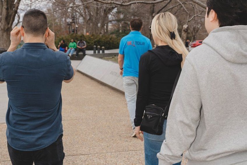 A group of people walking on a paved path in a park. 2