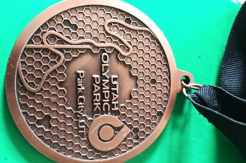 A bronze medal with 'UTAH OLYMPIC PARK' and 'Park City' engraved on it. 3